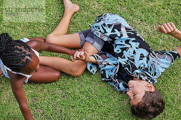 Brother (8-9) and sister (6-7) playing on back yard