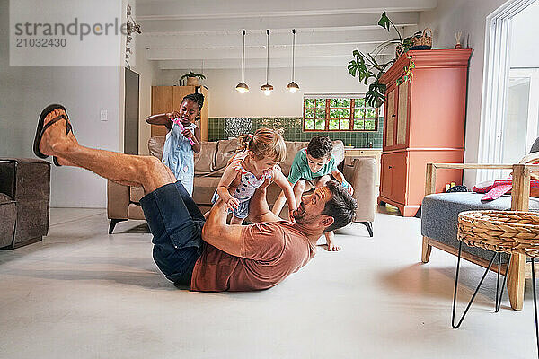 Father playing with children (18 - 23 months  6-7  8-9) at home