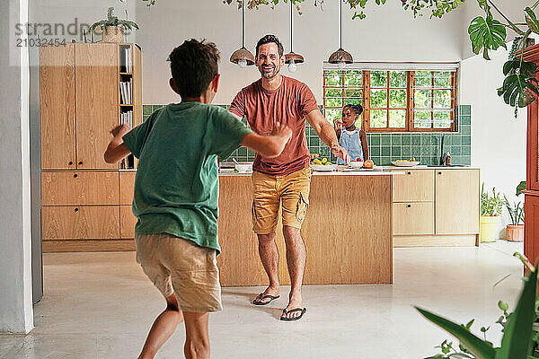 Happy father and son (8-9) in kitchen