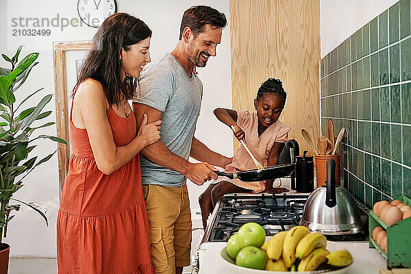 Parents with daughter (6-7) coking in kitchen