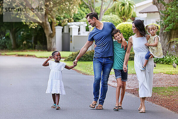 Parents with children (18-22 months  6-7  8-9) walking on street