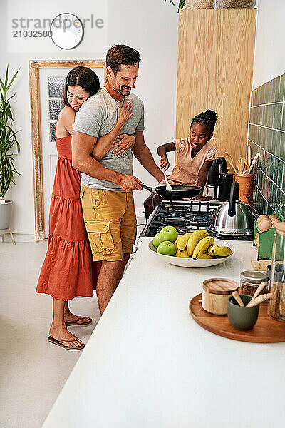 Parents with daughter (6-7) coking in kitchen