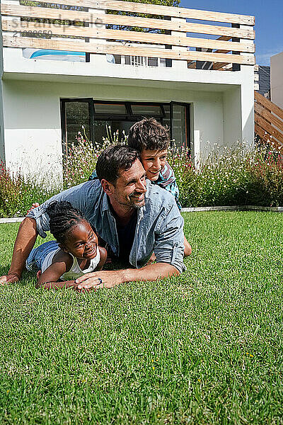 Father with children ( 6-7  8-9) playing on back yard