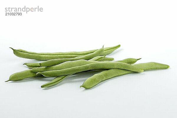 A close up photo of freshly harvested raw green beans on a white background