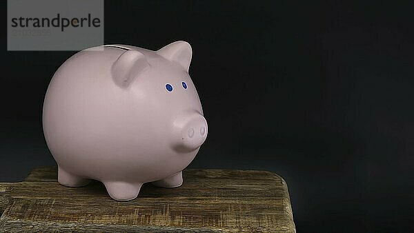 Ceramic piggy bank in close up over black background adding a sense of depth and contrast