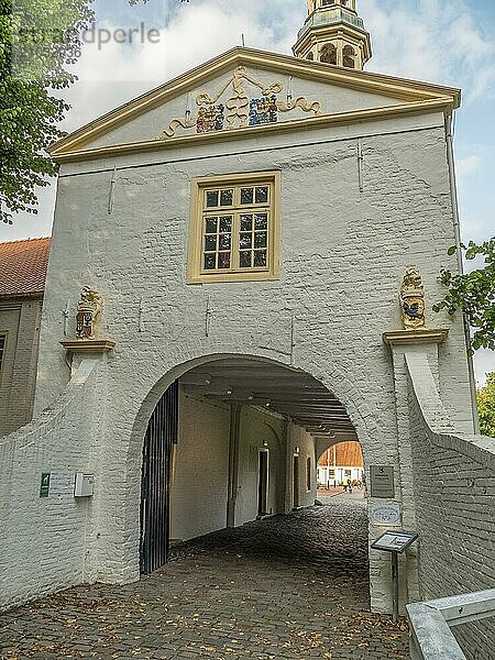 White building with a large archway  several windows and decorative details including cobblestones  dornum  east frisia  germany