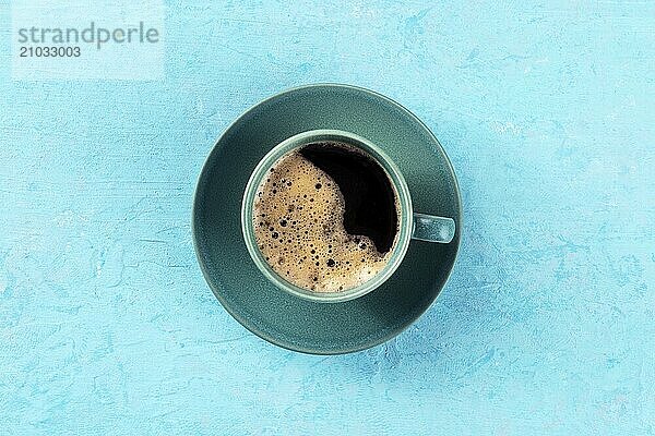 Coffee cup  overhead flat lay shot on a blue background  espresso drink on a turquoise table