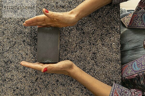 Top view of a tarot reader's hands arranging the deck of tarot cards