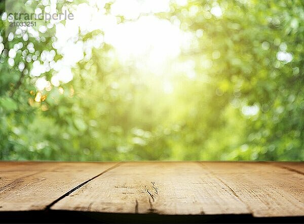 Empty wooden plank or deck  table top with background of blurred green trees  garden with sunlight or blurred foliage backyard. Nature with bokeh light. Mock up  template for product display  montage