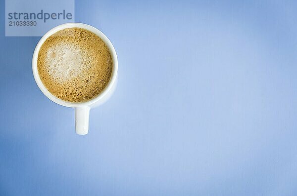 White cup of coffee on light blue background