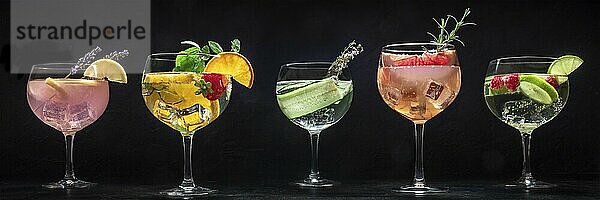 Fancy cocktails with fresh fruit panorama. Gin and tonic drinks with ice at a party  on a black background  a panoramic header  Food photography  Food photography