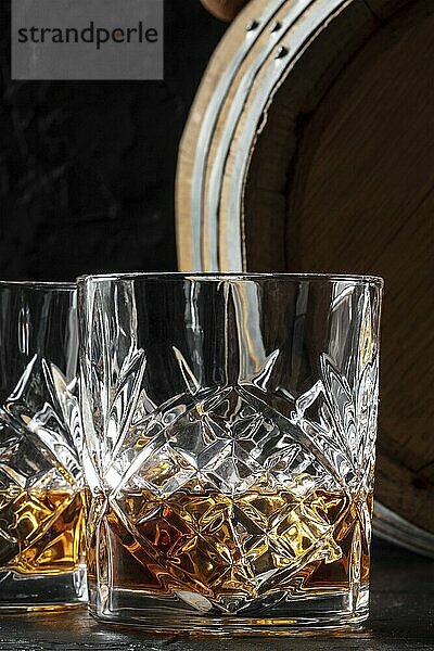 Whiskey in a glass with a barrel. Bourbon whisky and a cask on a dark background  an elegant close-up  Food photography