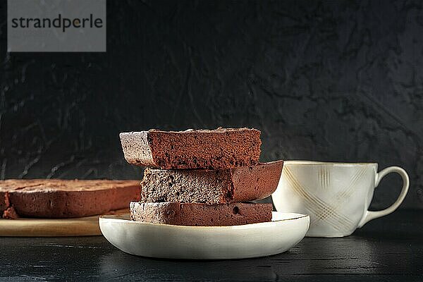 Chocolate brownie with tea  simple coffee cake  a side view on a black background with copy space  Food photography