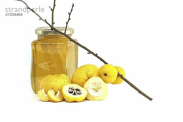 Glass with honey surrounded by vibrant quince fruits  both sliced and whole isolated on white background  full depth of field