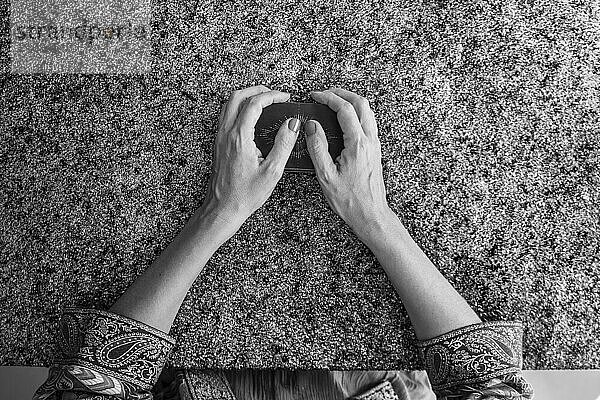 Top view of a tarot reader's hands holding the deck of tarot cards