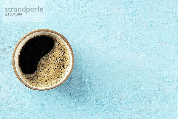 Coffee cup  shot from above on a blue background with a place for text  espresso drink on a vibrant table  Food photography