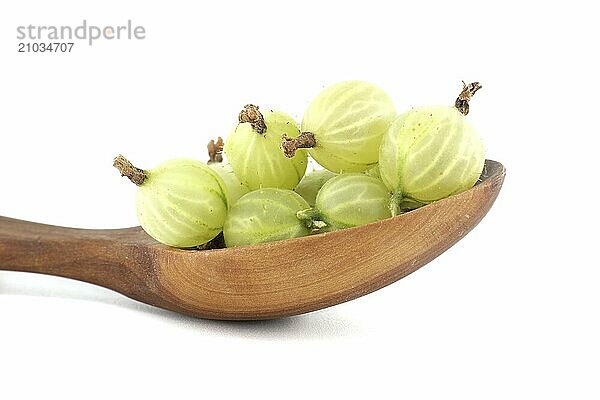 Green ripe gooseberries in a wooden spoon isolated on white background  low angle view