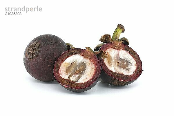 Whole and cut in half mangosteen fruits revealing its white interior flesh dotted with dark purple spots and containing two visible black seeds isolated on white background