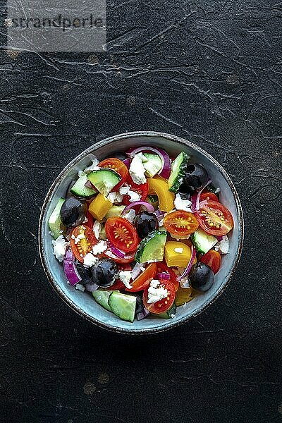 Greek salad. Fresh tomato  cucumber  bell pepper  Feta cheese  onion  and olives. Healthy summer food  overhead flat lay shot on a black background