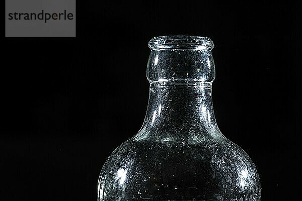 Top of a glass bottle on black background