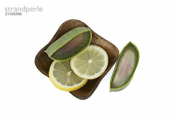 Aloe Vera leaf and lemon slices in a wooden plate isolated on white background  top view  natural organic cosmetic ingredients for sensitive skin  alternative medicine