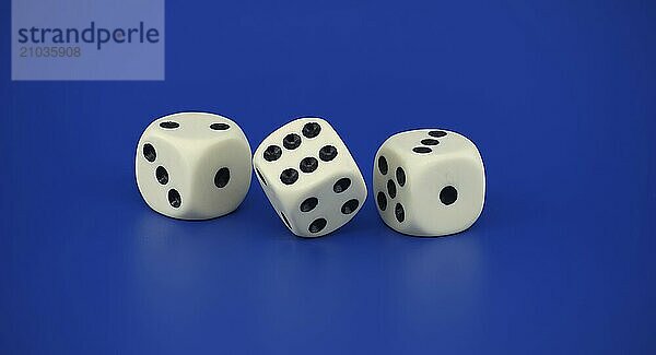 Gaming scenario scene with three dice with black spots situated on a blue background