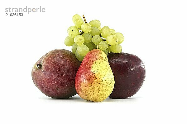 Assortment of fresh healthy fruits including multicolored mango  pears and green grapes and apple isolated on a white background