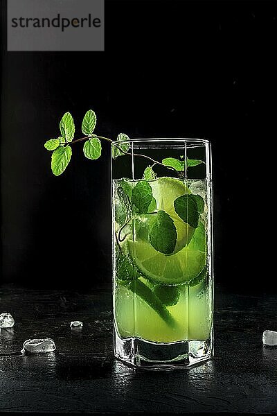 Mojito cocktail. Summer cold drink with lime  fresh mint  and ice. Cool beverage  side view on a black background  Food photography  Food photography