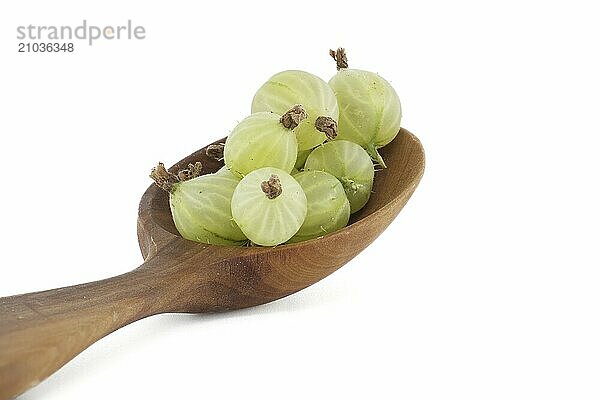 Green ripe gooseberries in a wooden spoon isolated on white background