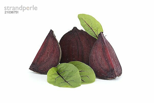 Slices of beetroot revealing their vibrant purple interiors complete with their fresh green leaves set against white background