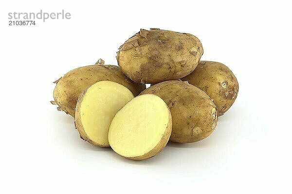 Early season potatoes with a light brown skin isolated on a white background  one potato bisected displaying its yellow interior