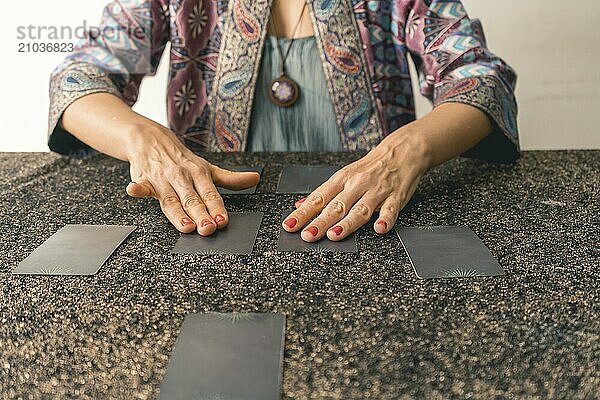 Engaging tarot reader ready to give a tarot reading  holding cards prior to turning them ove