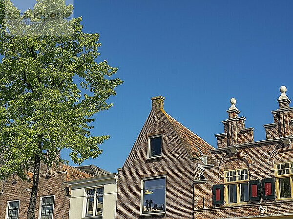 Traditional brick houses with repeating windows and light textures under a clear blue sky  alkmaar  the netherlands