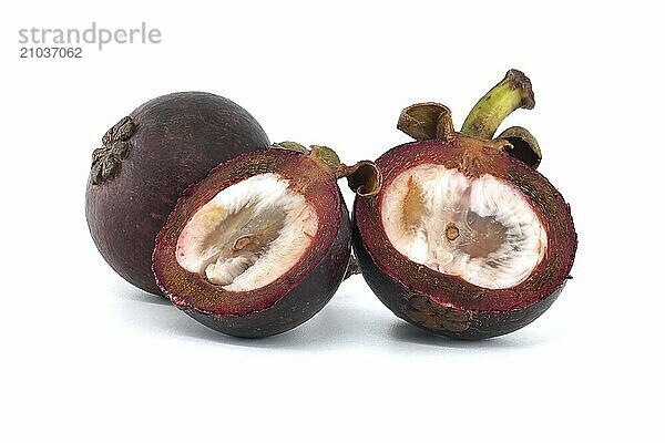 Whole and halved mangosteen fruits display their white inner flesh  speckled with dark purple spots and featuring two discernible black seeds  set against a white background