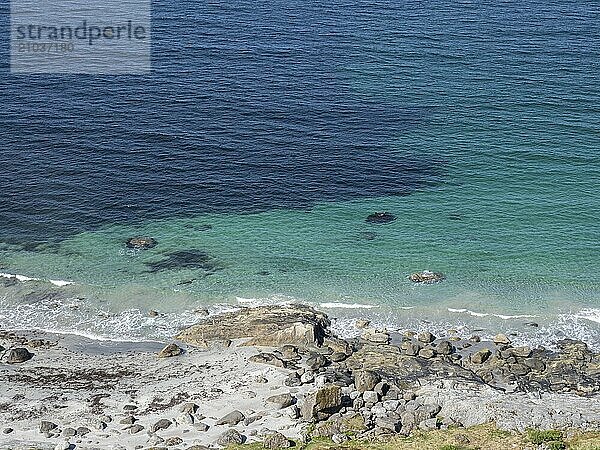 Rocky sandy beach with turquoise water on the Norwegian coast