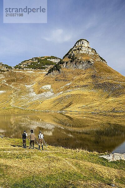 The Austrian alphorn trio Klangholz plays the alphorn at Lake Augstsee on Mount Loser. Mount Atterkogel in the background. Autumn  good weather  blue sky. Reflection. Altaussee  Bad Aussee  Ausseer Land  Totes Gebirge  Styria  Upper Austria  Austria  Europe