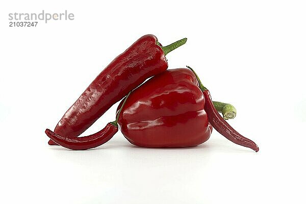 A stack of fresh chili peppers and red bell peppers isolated on white background