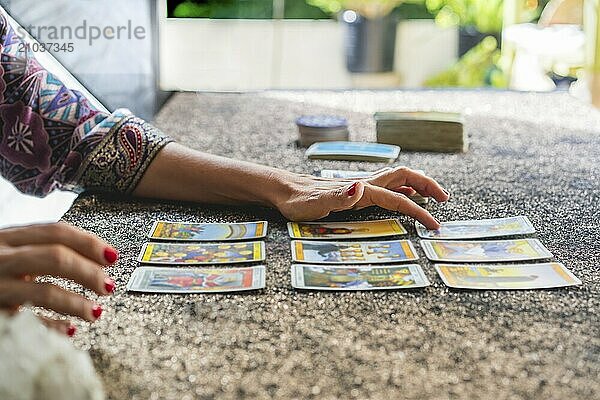 Side view of a tarot reader's hands reading the cards