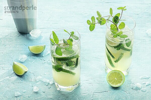 Mojito cocktail. Summer cold drink with lime  fresh mint  and ice. Cool beverage on a blue background with ingredients  Food photography  Food photography