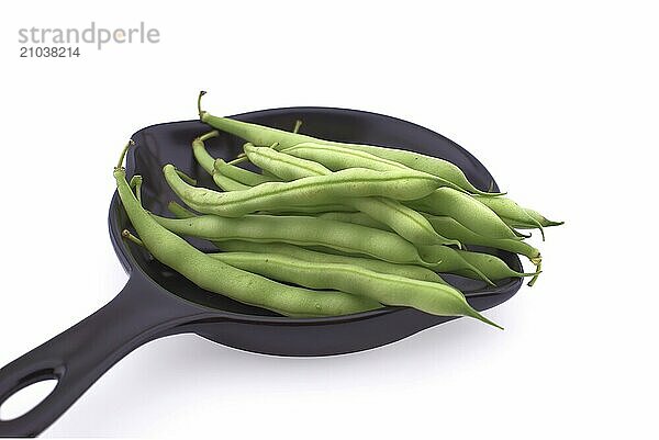 A handful of green beans in the cooking pan isolated on white background. Healthy  nutritious vegetarian food