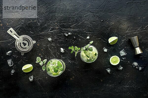 Mojito cocktail. Summer cold drink with lime  fresh mint  and ice. Cool beverage on a black background  overhead flat lay shot  Food photography  Food photography