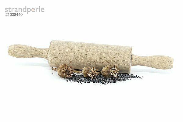 Dried poppy pods and poppy seeds in front of the rolling pin isolated on white background  full depth of field