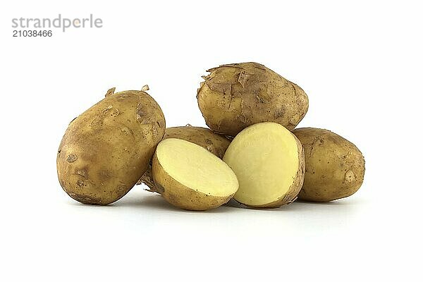 Early season potatoes with a light brown skin isolated on a white background  one potato bisected displaying its yellow interior