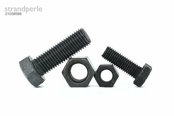 Orderly arrangement of dark-colored metal of hex bolts and nuts include long and shorter parts  placed against a clean  white background