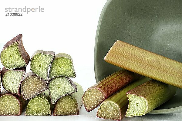 Variety of rhubarb stalks of varying colors from pale green to deep red isolated on white background  illustrate a recipe for a rhubarb-based dish