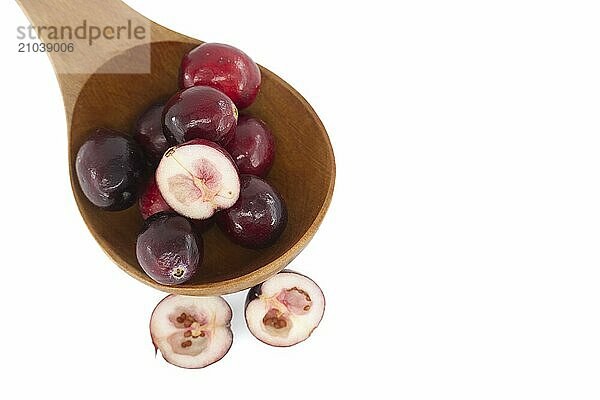 Half cut cranberry berry and fresh cranberries in wooden spoon isolated on white background  top view