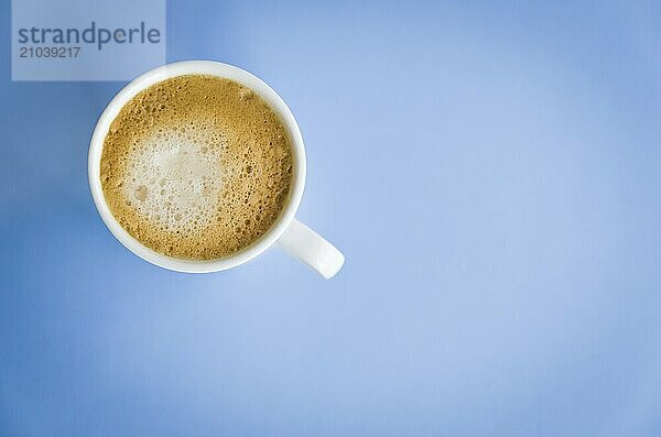 White cup of coffee on light blue background