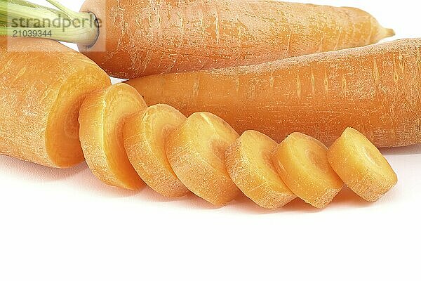 Whole carrot and sliced pieces  all with a bright orange color prepped for cooking or for use in a dish like a salad or stir-fry isolated on a white background