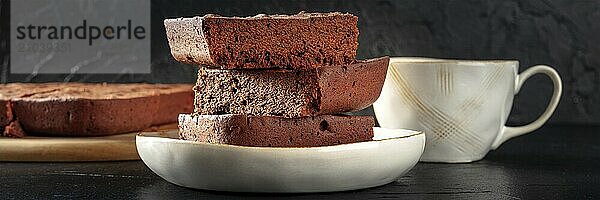 Chocolate brownie with tea panorama  simple coffee cake  a side view on a black background