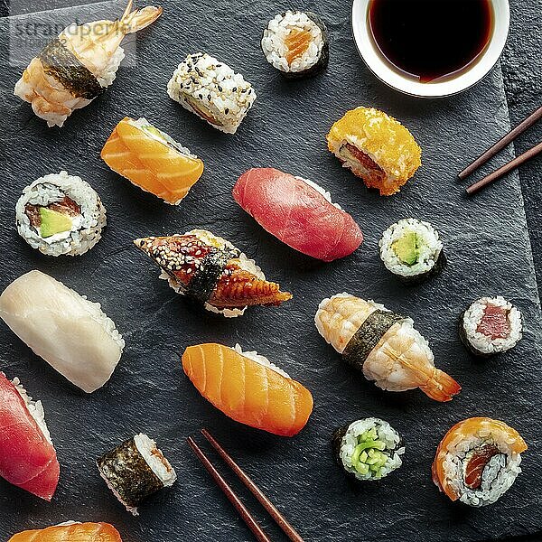 Sushi  overhead square shot with chopsticks and soy sauce. Rolls  maki  nigiri on a black background  Japanese food. Salmon  tuna  eel  shrimp and other seafood  Food photography  Food photography